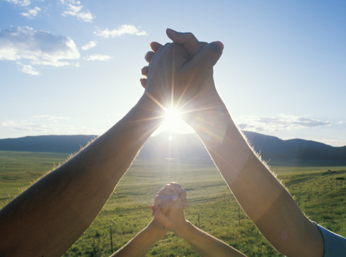 Holding Hands with Sun in the background